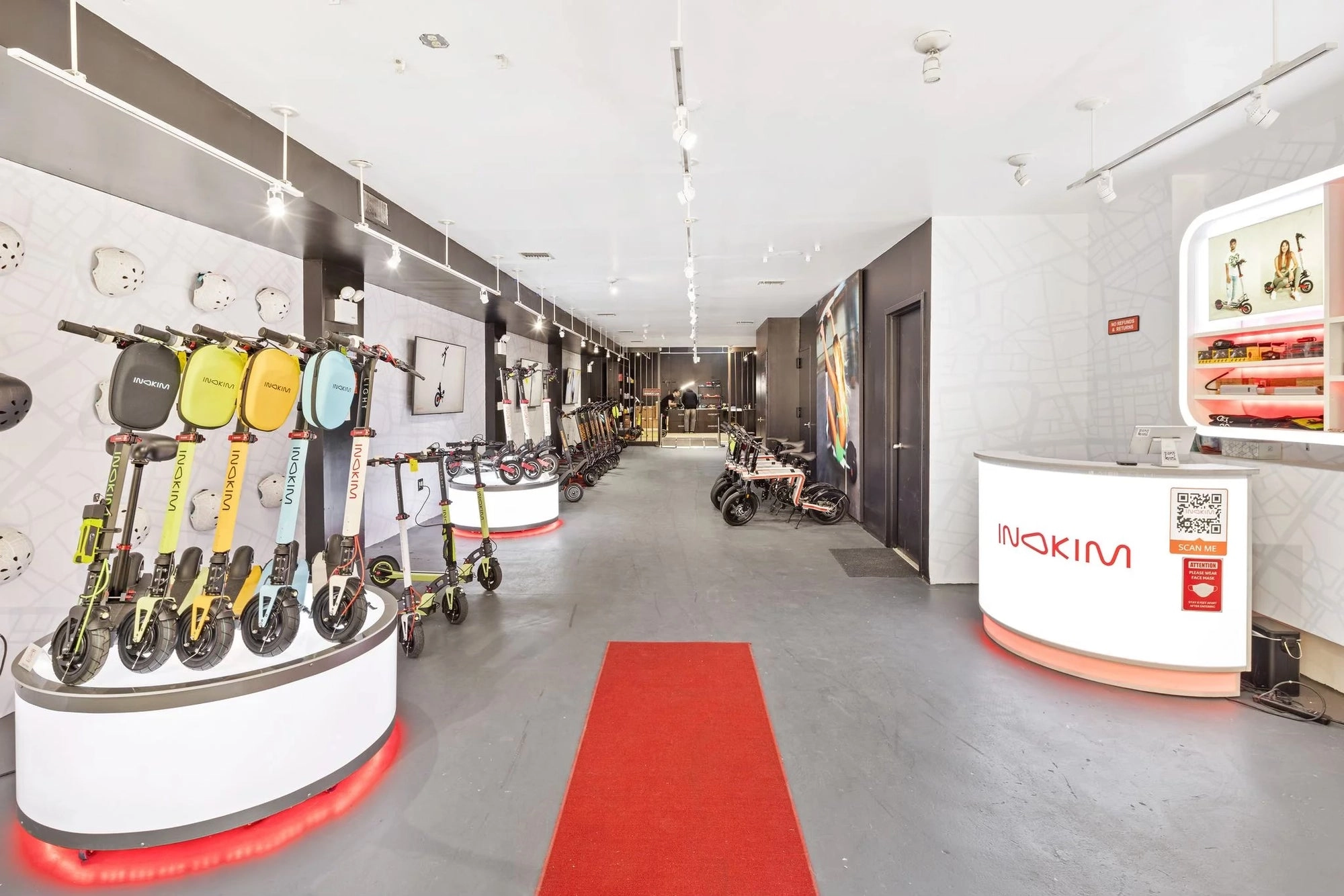 Inside an Inokim store: scooters on the wall, a red carpet and a service counter